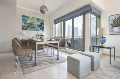 a dining room with a table and chairs and a large window at Frank Porter - Al Majara Tower 2 in Dubai
