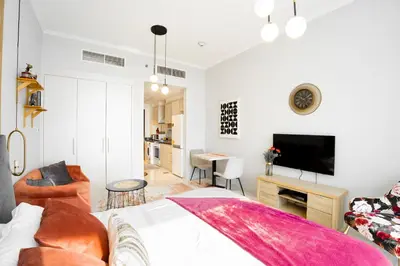 a living room with a couch and a tv in a room at Sleek Studio in Damac Hills - Premium Living with Top-Class Amenities, Managed by Think Realty in Dubai