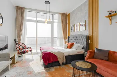 a bedroom with a bed and a couch at Sleek Studio in Damac Hills - Premium Living with Top-Class Amenities, Managed by Think Realty in Dubai