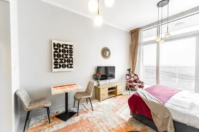 a bedroom with a bed and a desk and a tv at Sleek Studio in Damac Hills - Premium Living with Top-Class Amenities, Managed by Think Realty in Dubai