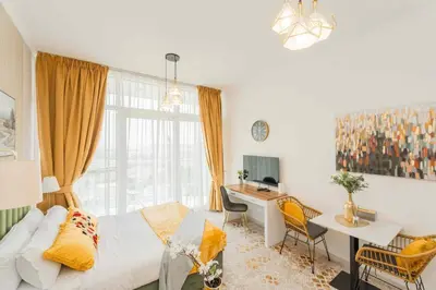 a bedroom with a bed and a desk and a table at Golf View Studio in Damac Hills - Luxury Living, Exclusive Amenities, by Think Realty in Dubai