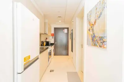 a hallway leading to a kitchen with white walls at Golf View Studio in Damac Hills - Luxury Living, Exclusive Amenities, by Think Realty in Dubai