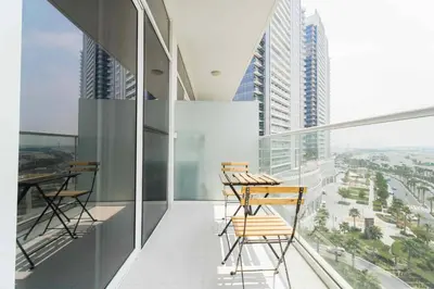 a balcony with chairs and a view of a city at Golf View Studio in Damac Hills - Luxury Living, Exclusive Amenities, by Think Realty in Dubai