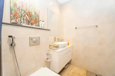 a bathroom with a sink and a toilet and a painting at Golf View Studio in Damac Hills - Luxury Living, Exclusive Amenities, by Think Realty in Dubai