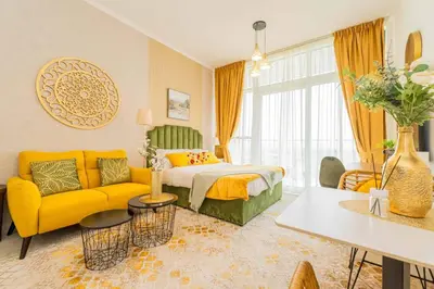 a living room with a bed and a yellow couch at Golf View Studio in Damac Hills - Luxury Living, Exclusive Amenities, by Think Realty in Dubai