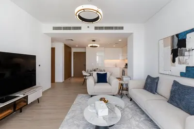 a living room with a couch and a tv at Palace Residence, Dubai Creek Harbour - Mint Stay in Dubai