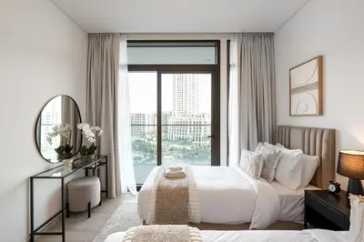 a bedroom with a bed and a desk and a window at Palace Residence, Dubai Creek Harbour - Mint Stay in Dubai