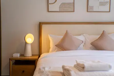 a bedroom with a bed with a lamp on a table at SettlerHomes - Chic Creek Edge 1BR With Harbour View in Dubai