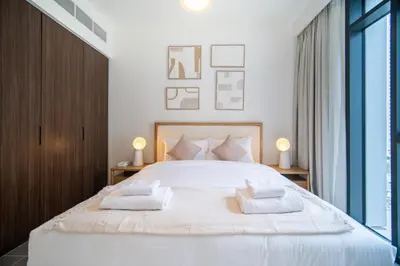 a bedroom with a large white bed with two pillows at SettlerHomes - Chic Creek Edge 1BR With Harbour View in Dubai