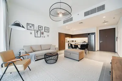 a living room with a couch and a table at SettlerHomes - Chic Creek Edge 1BR With Harbour View in Dubai