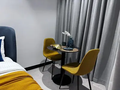 a room with a table with two chairs and a bed at Cosy Studio on the Binghatti Canal in Dubai
