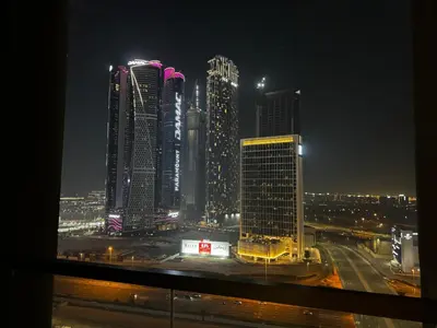 a view of a city at night with tall buildings at Cosy Studio on the Binghatti Canal in Dubai