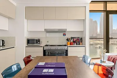 a kitchen with a table and a kitchen with a view at Silkhaus Large 3BR plus Maid Room Elegant Marina View in Dubai