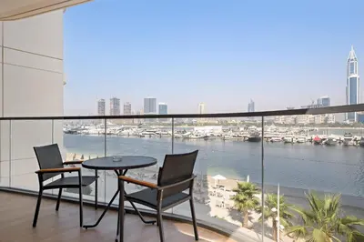 a balcony with a table and chairs and a view of a harbor at Silkhaus Large 3BR plus Maid Room Elegant Marina View in Dubai