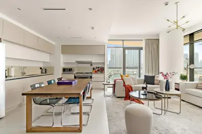 a kitchen and living room with a table and chairs at Silkhaus Large 3BR plus Maid Room Elegant Marina View in Dubai