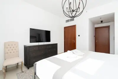 a bedroom with a bed and a tv and a chair at Downtown,Fountain view, nearBurj Khalifa,3 minutes walk to Dubai Mall in Dubai
