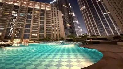 a large swimming pool in a city with tall buildings at Downtown,Fountain view, nearBurj Khalifa,3 minutes walk to Dubai Mall in Dubai