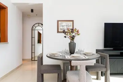 a dining room table with chairs and a vase with flowers at Downtown,Fountain view, nearBurj Khalifa,3 minutes walk to Dubai Mall in Dubai