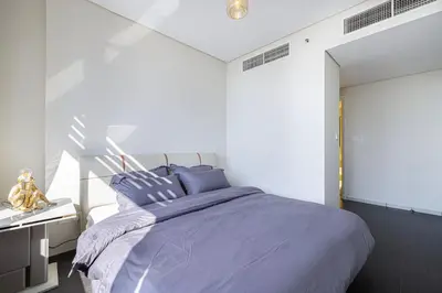 a bedroom with a large bed with blue pillows at Heart of DIFC 1 BR LUX - Exceptional View in Dubai