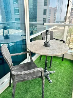 a table and two chairs on a balcony with grass at Vacation Friendly Beach View Luxury 1Bedroom- Walk To Beach & Mall in Dubai