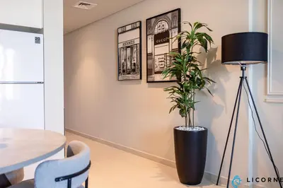 a plant in a black vase on a wall with pictures at New Stylish 1BR Apartment, Next to Dubai Mall - Downtown Views ll, Tower 3 in Dubai