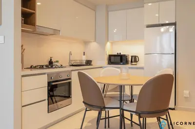 a kitchen with a table and chairs and a refrigerator at Top Floor Urban Oasis Steps from Dubai Mall - 1BR Apartment in Downtown Views ll, Tower 1 in Dubai