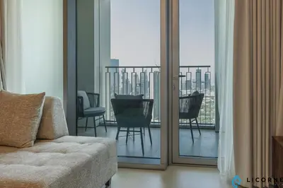 a living room with a couch and a balcony at Top Floor Urban Oasis Steps from Dubai Mall - 1BR Apartment in Downtown Views ll, Tower 1 in Dubai