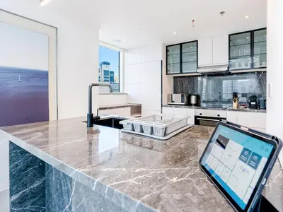 an ipad sitting on a counter in a kitchen at 2 Bedroom Smart Home with a Panoramic Marina View in Dubai