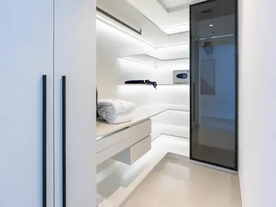 a kitchen with white cabinets and a glass door at 2 Bedroom Smart Home with a Panoramic Marina View in Dubai
