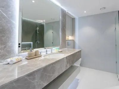 a bathroom with a sink and a large mirror at 2 Bedroom Smart Home with a Panoramic Marina View in Dubai