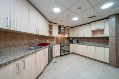 a large kitchen with wooden cabinets and appliances at Spacious 3 Bedroom Palm Apartment in Dubai