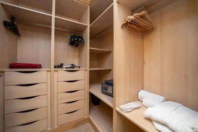 a walk in closet with wooden shelves and drawers at Spacious 3 Bedroom Palm Apartment in Dubai