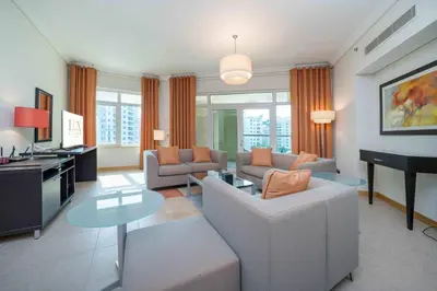 a living room with a couch and a piano at Spacious 3 Bedroom Palm Apartment in Dubai
