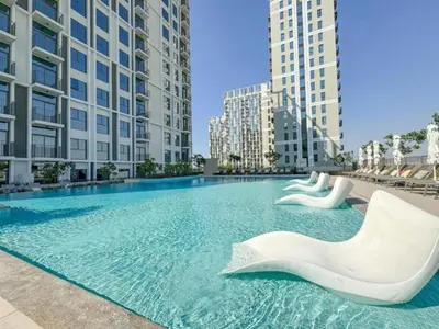 a large swimming pool with two white sculptures in a city at Socio Tower 2 - Neat One Bedroom in Dubai