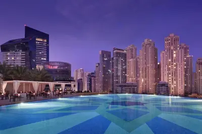 a large swimming pool in front of a city skyline at Vacationer l Bright 1 Bedroom l Marina & Yacht Views l Pool access & Free Wi-Fi in Dubai