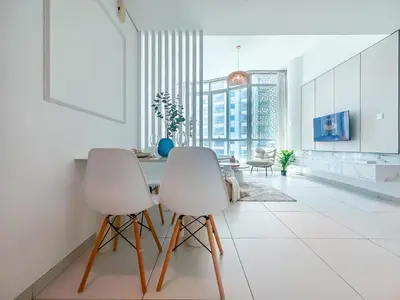 two white chairs in a white kitchen with a view at Amazing Roof Top Pool in Nice 1 BHK Flat in Marina in Dubai