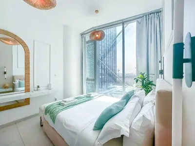 a bedroom with a bed and a large window at Amazing Roof Top Pool in Nice 1 BHK Flat in Marina in Dubai