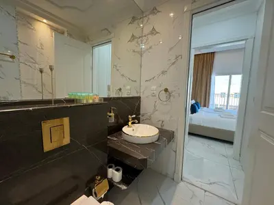 a bathroom with a sink and a large mirror at ASHRI Luxurious Apartment in Arjan near Miracle Gardens in Dubai