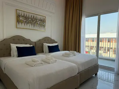 a bedroom with a large bed with towels on it at ASHRI Luxurious Apartment in Arjan near Miracle Gardens in Dubai