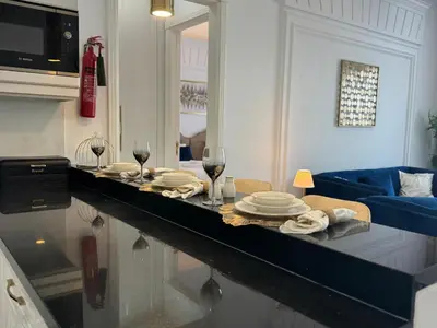 a living room with a table with plates and wine glasses at ASHRI Luxurious Apartment in Arjan near Miracle Gardens in Dubai