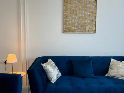a blue couch with two pillows in a living room at ASHRI Luxurious Apartment in Arjan near Miracle Gardens in Dubai