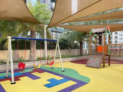 a play area with swings and a slide at Marina View 1BR Chic Stay in Dubai Vibrant Walk Near Dining & Attractions in Dubai