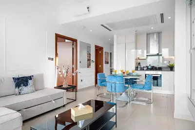 a living room with a couch and a table and blue chairs at Marina View 1BR Chic Stay in Dubai Vibrant Walk Near Dining & Attractions in Dubai
