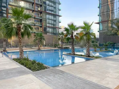 a swimming pool with palm trees in a building at Marina View 1BR Chic Stay in Dubai Vibrant Walk Near Dining & Attractions in Dubai
