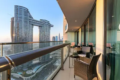 a balcony with chairs and a view of a city at Downtown 2BR Skyline Views & Prime Dubai Stay Near Burj Khalifa, Mall in Dubai