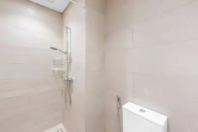 a white bathroom with a shower and a toilet at FIRST CLASS Studio Sophisticated Getaway in Dubai