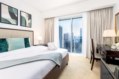 a bedroom with a bed and a desk and a window at Charming 1BR in The Address Residences Dubai Marina by Deluxe Holiday Homes in Dubai