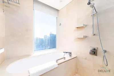 a bathroom with a bath tub and a window at Charming 1BR in The Address Residences Dubai Marina by Deluxe Holiday Homes in Dubai