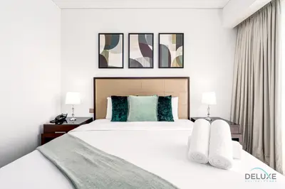 a bedroom with a large white bed with two lamps at Charming 1BR in The Address Residences Dubai Marina by Deluxe Holiday Homes in Dubai