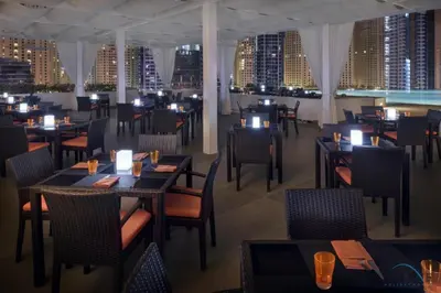 a restaurant with tables and chairs and a view of the city at Charming 1BR in The Address Residences Dubai Marina by Deluxe Holiday Homes in Dubai